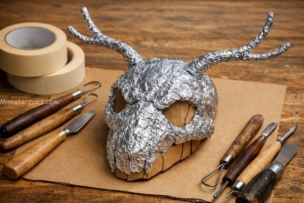 Step-by-step DIY skull crafting process showing aluminum foil and wire armature construction
